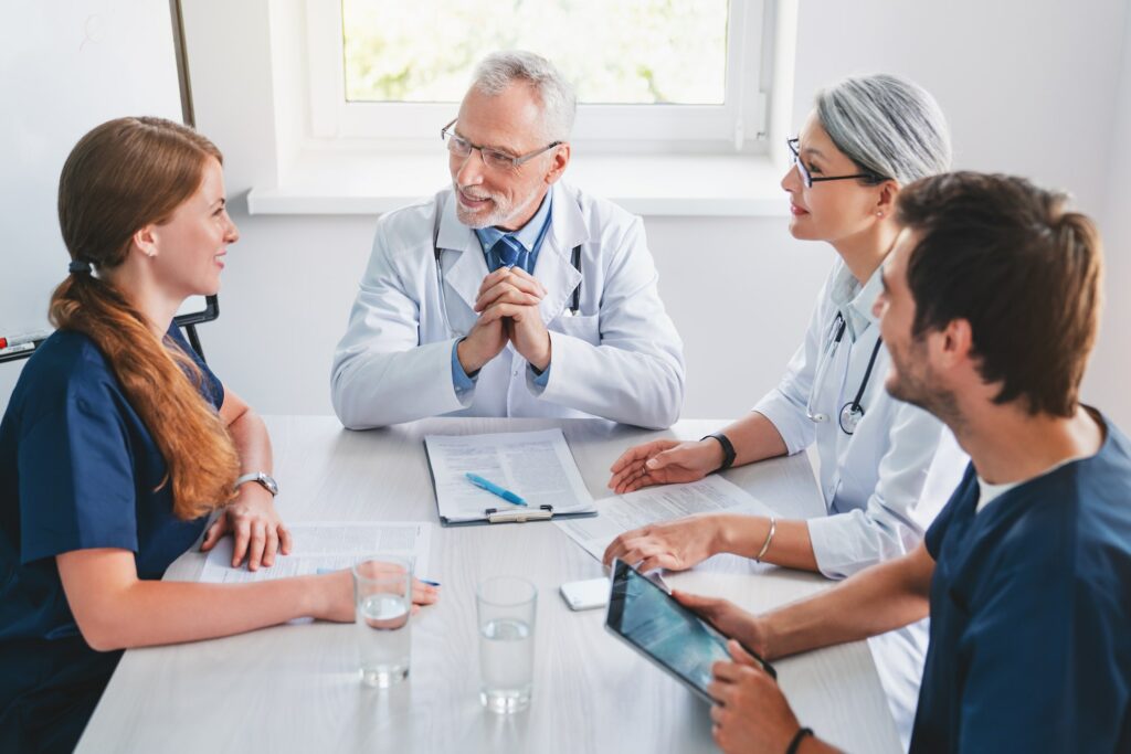Healthcare professionals team having discussion in hospital meeting room.