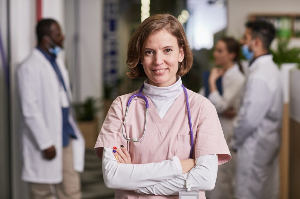 Young happy female general practitioner or nurse in medical scrubs